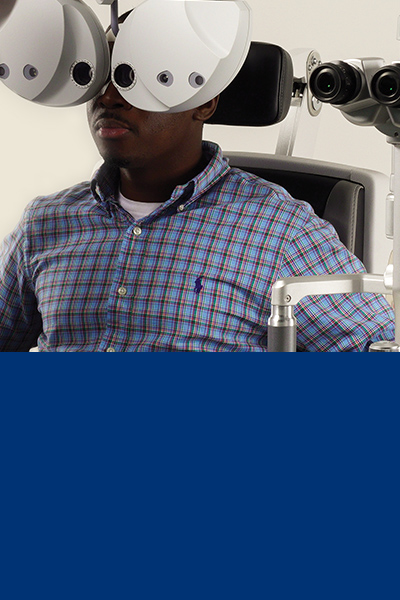 Image depicting a man having his eyes tested by an optical device